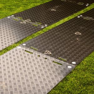 Quelles plaques de roulage utiliser pour protéger un terrain naturel lors d'un concert ?