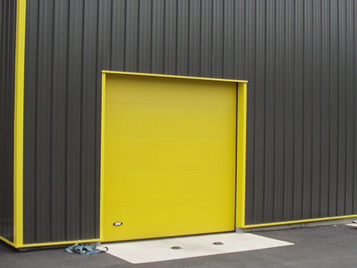 Porte sectionnelle industrielle avec levée anti-effraction, hublot et portillon - Isolation Phonique 25 dB_0
