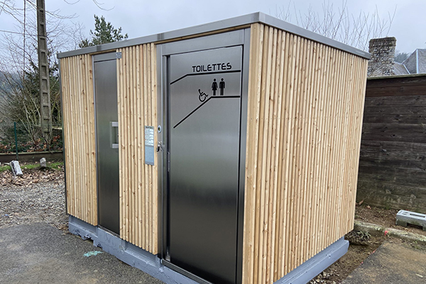 Cabine PMR avec mur urinoir, équipée de local technique, de finitions extérieures en bois, en trespa et en béton - référence 2073_0