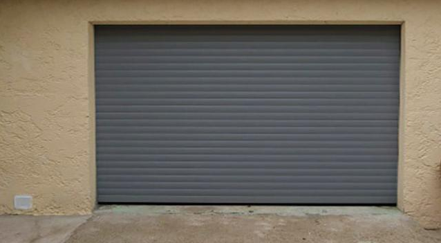 Porte de garage enroulable / motorisée / lames en acier / avec portillon et hublots / isolation thermique_0
