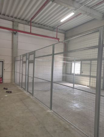 Cloison grillagée pour délimiter les espaces de stockage