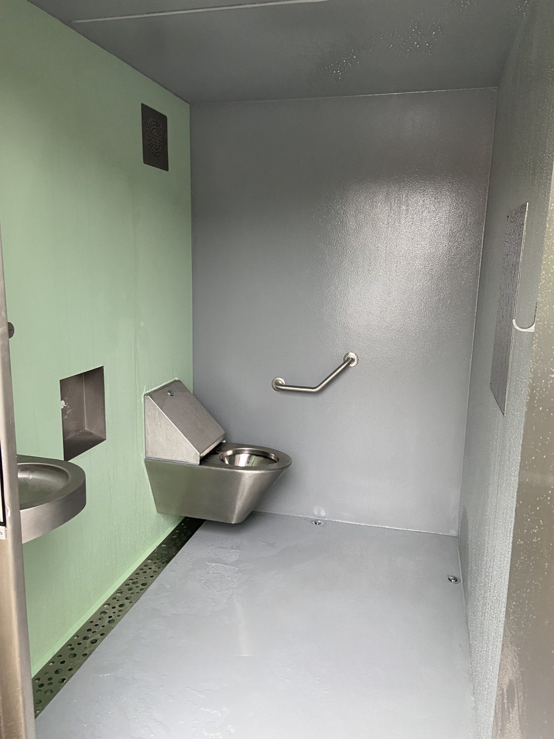 Cabine PMR avec mur urinoir, équipée de local technique, de finitions extérieures en bois, en trespa et en béton - référence 2073_1