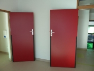 Porte avec vantail en panneau de fibres de bois dur et bourrelets anti-pince doigts