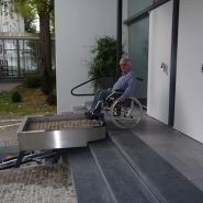 Plateforme escamotable transportant une personne en fauteuil roulant