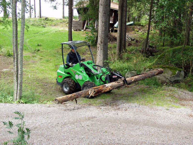 Pince à bois montée sur fourche à palettes pour manipuler des branches