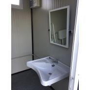 Cabine sanitaire avec porte d'accès équipée d'une barre anti-panique