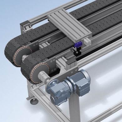 Ligne de transfert compacte pour porte-pièces avec chaîne plate à charnières