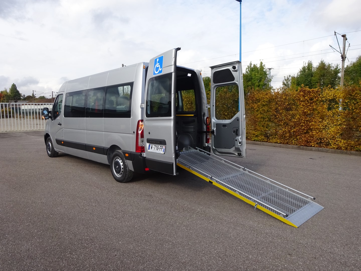 Véhicule utilitaire TPMR avec rails de fixation et rampes