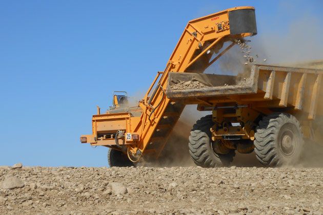 Machine pour déterrage de pierres avec tapis à barreaux