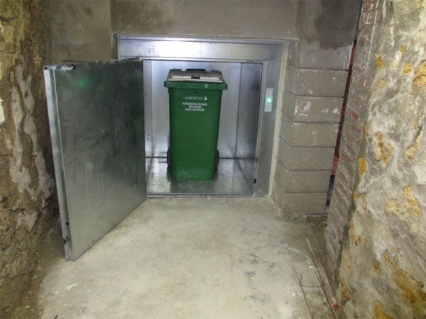 Équipement de levage pour fûts avec porte battante